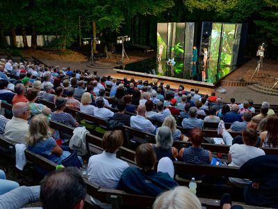 Das Bild zeigt eine Waldbühne aus Zuschauersicht. 