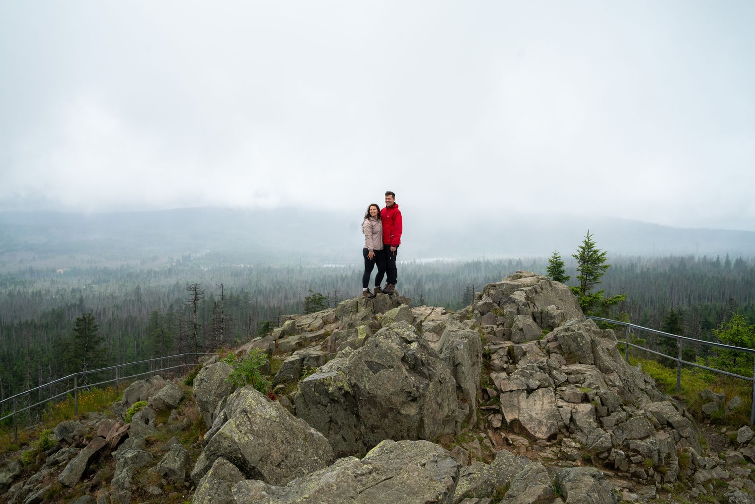 Geschafft! Die Wanderer haben den felsigen Gipfel der Achtermannshöhe im Nationalpark Harz erklommen und genießen nun den atemberaubenden Rundblick.