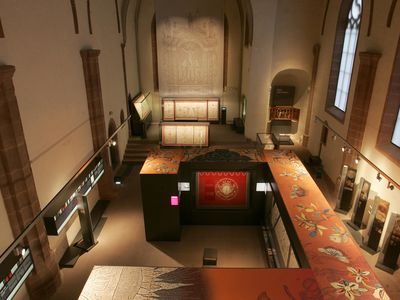 Das Bild zeigt eine Ausstellung mit Vitrinen in der Klosterkirche Brunshausen von oben fotografiert.
