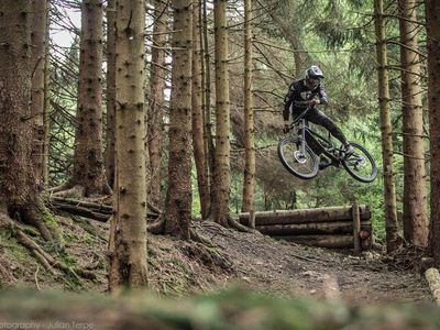 Das Bild zeigt einen Mountainbiker beim Sprung im Bikepark. 