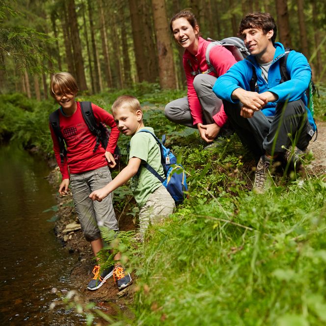 Familie erkundet Graben bei der Wanderung in der Oberharzer Wasserwirtschaft.