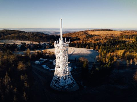Moderner HEX Aussichtsturm in winterlicher Hügellandschaft mit Wald und weiten Ausblicken im Harz.