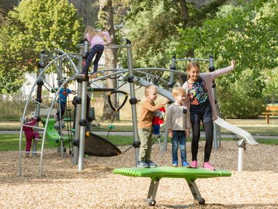 Das Bild zeigt spielende Kinder auf einem Spielplatz.